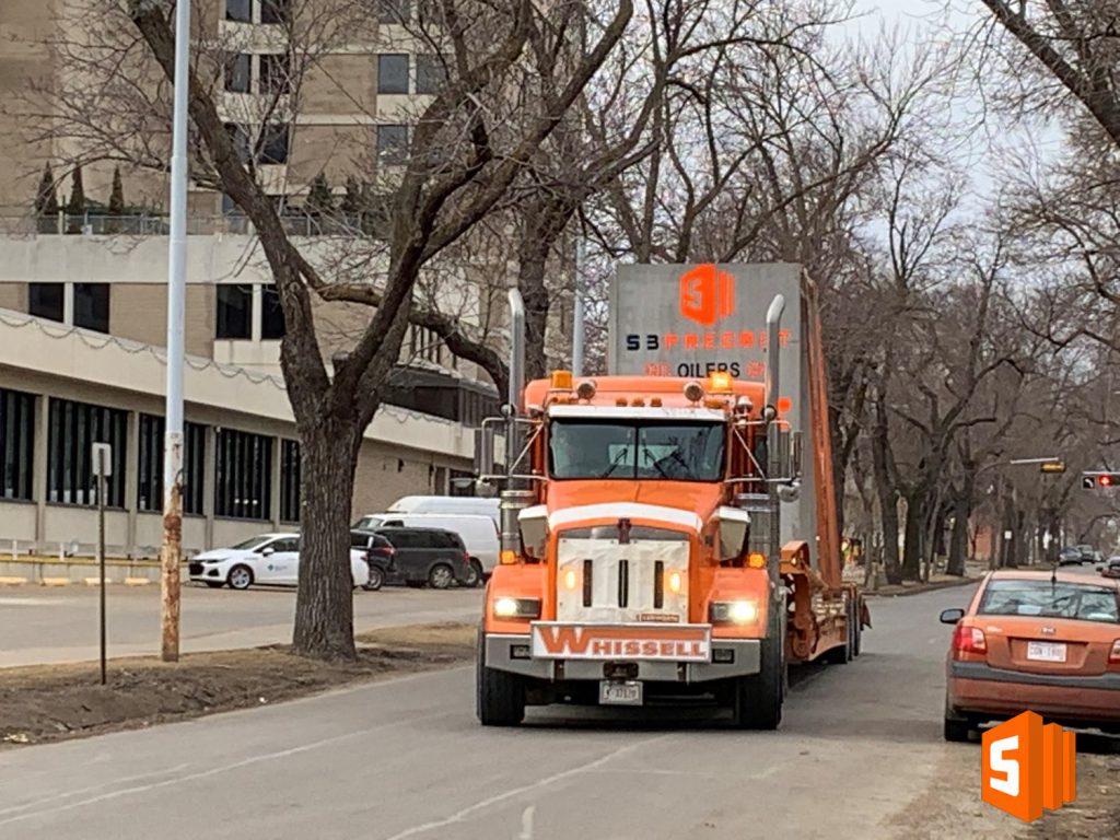 orange transport truck carrying precast concrete