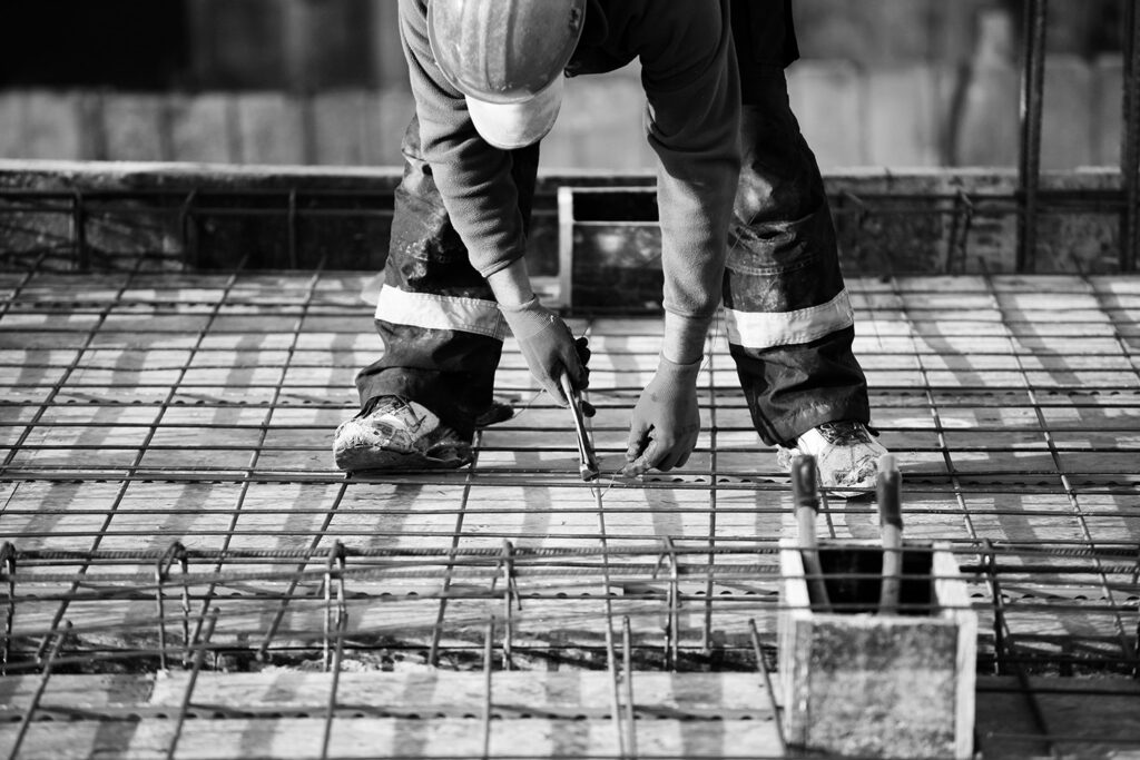 skilled worker installing rebar for concrete foundation