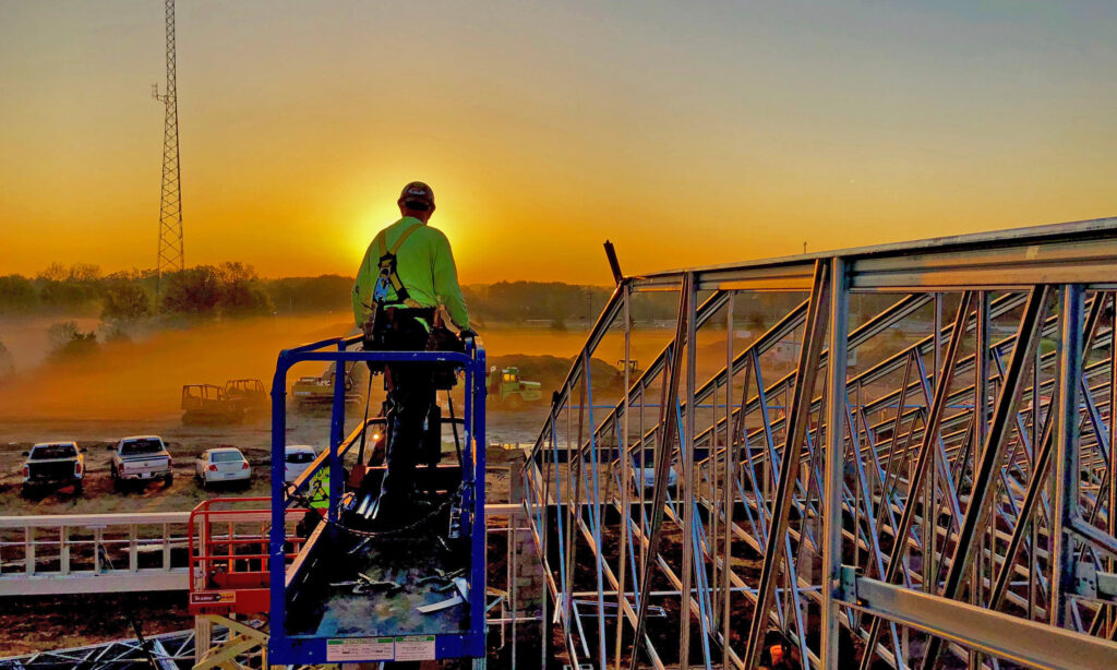 CCC worker standing on lift looking out into sunset