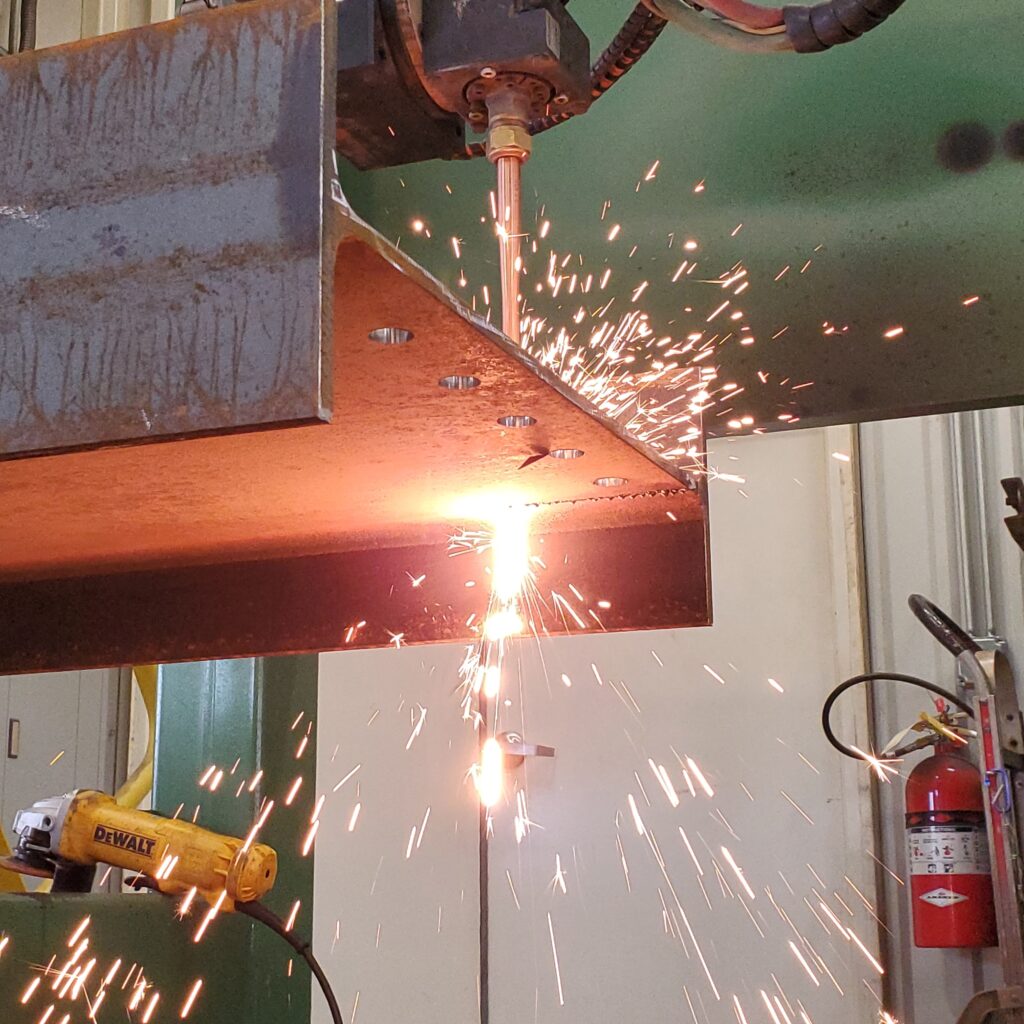 closeup of drill in action through metal beam