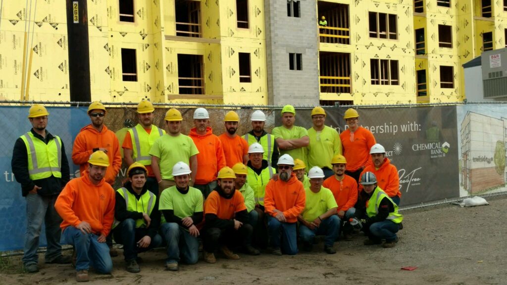 Consolidated Electrical Contractors workers in front of building under construction