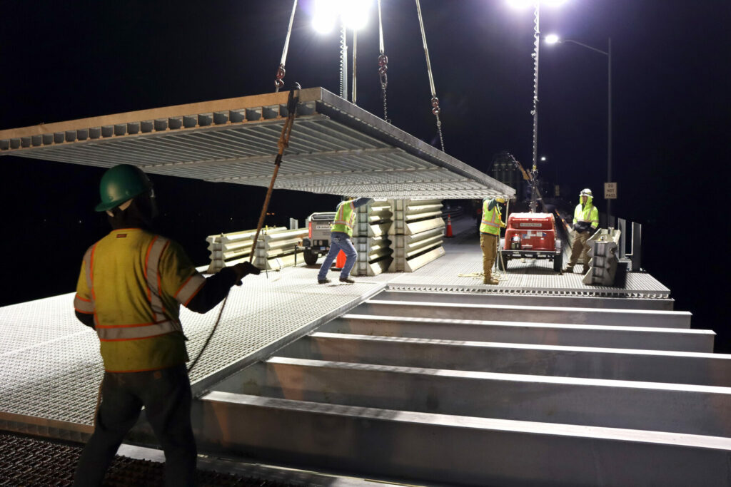 piasecki steel workers doing construction on bridge at night