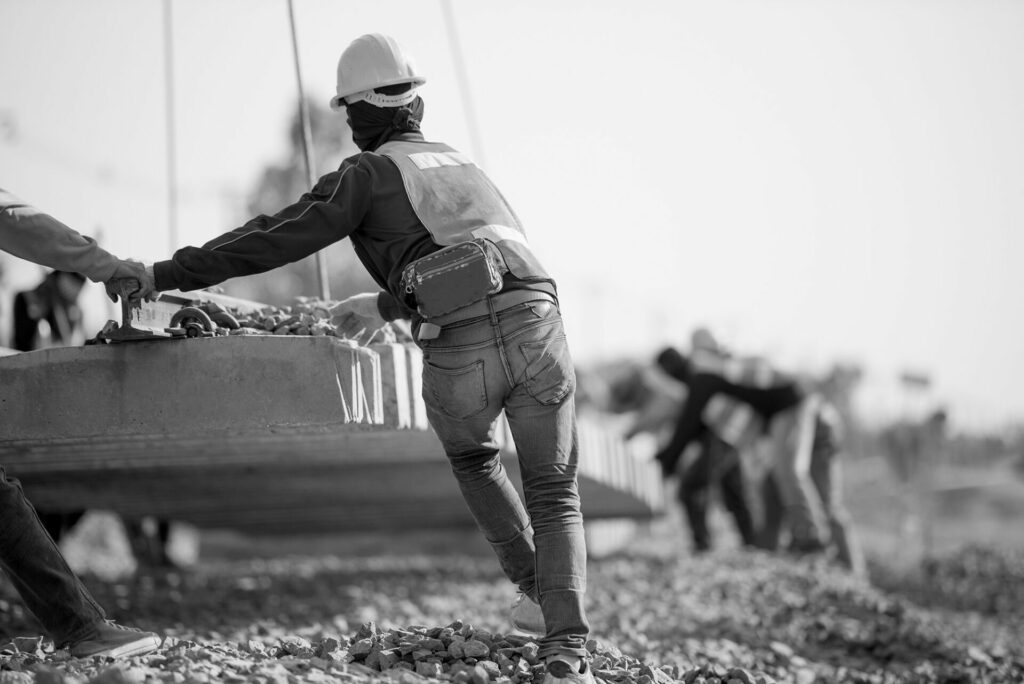 workers on site guiding concrete slab
