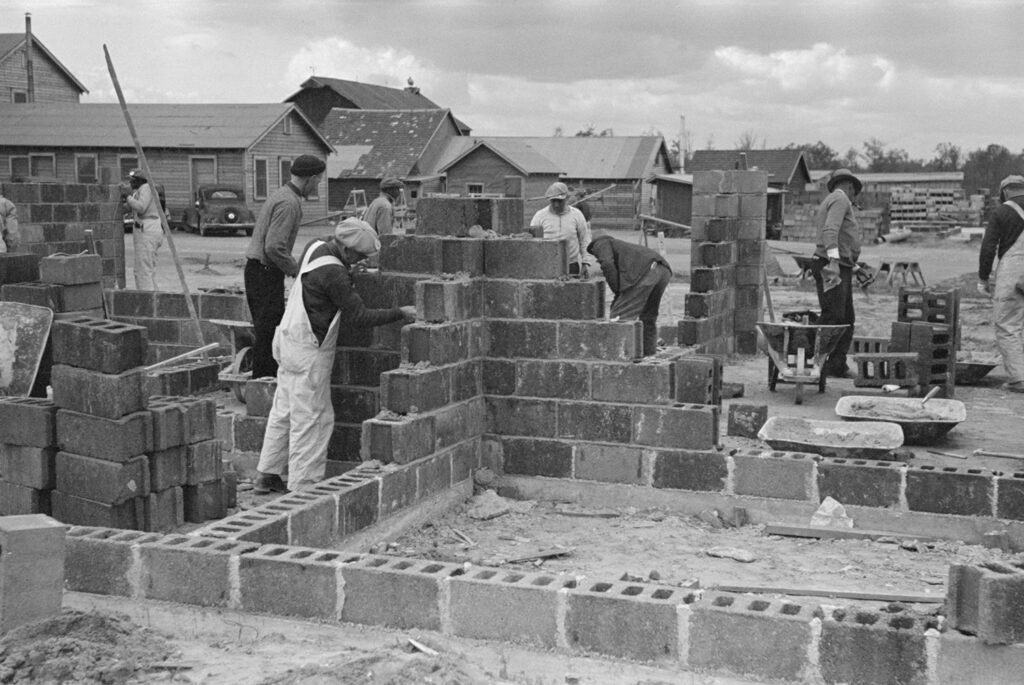 old photo of workers building wtih concrete blocks