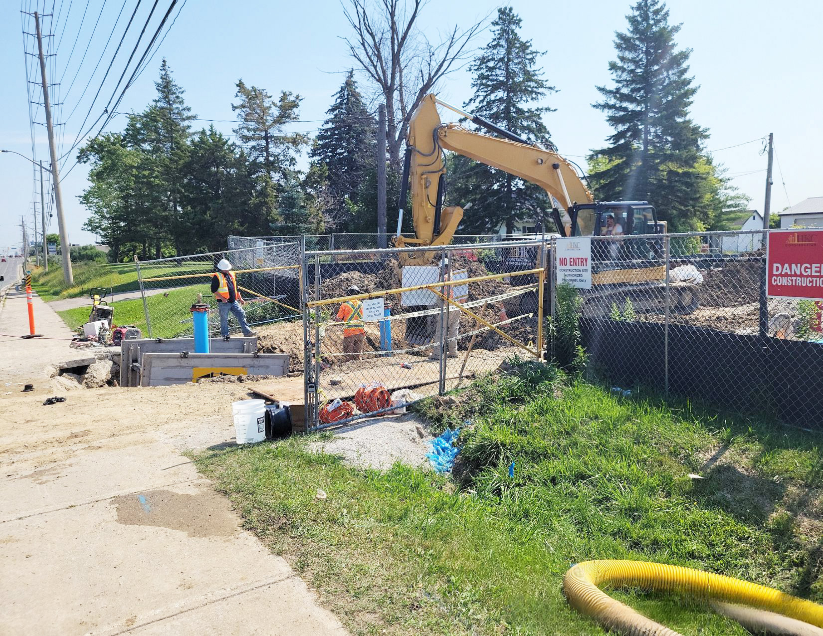 Fenced in construction side with excavator.