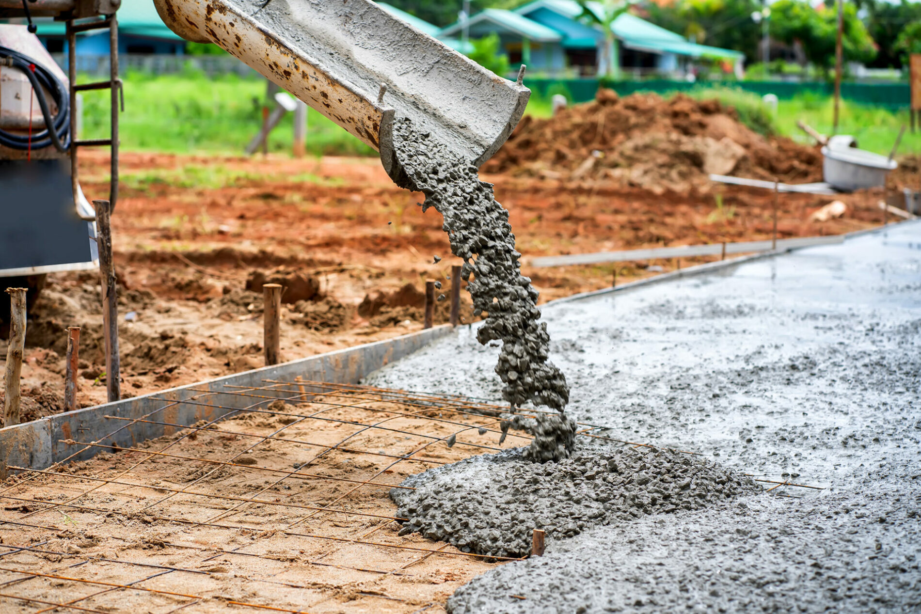 Construction workers supervise the pouring of concrete on the construction site.