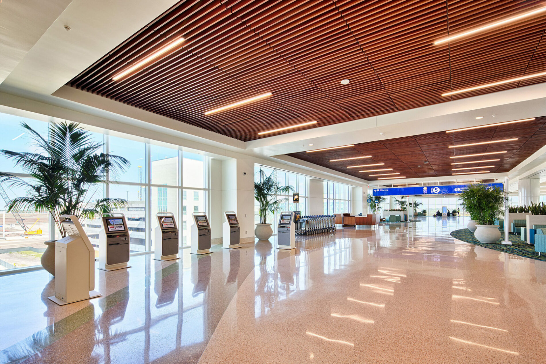 The interior of an airport, wood accents, high ceilings and bright lights.