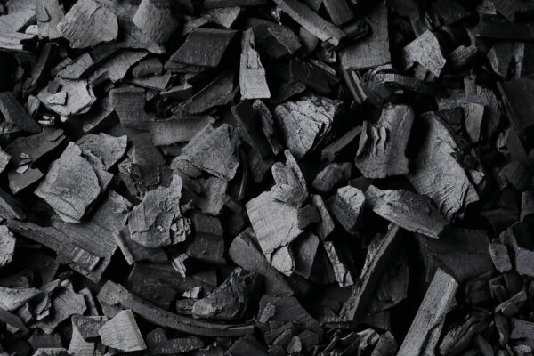 Black charcoal texture background. Close-up
