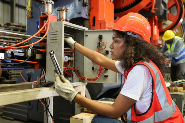 the young lady worker operate or repair electric distribution board circuit of the metal machine tool in factory or machinery industry