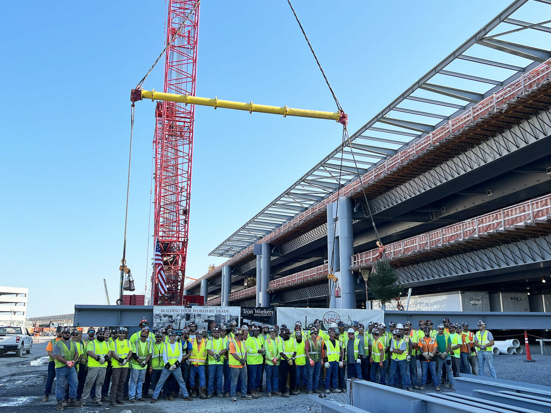 A photo of a steel construction site with group of people standing together.