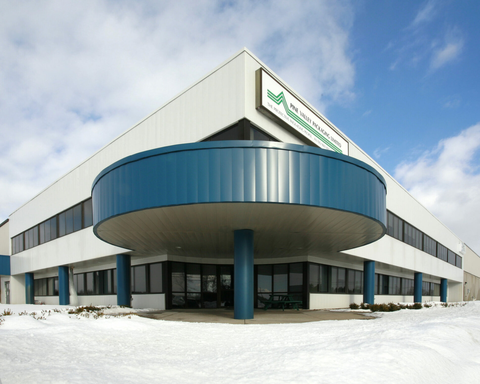 A photo of a building with interesting features with snow on the ground.