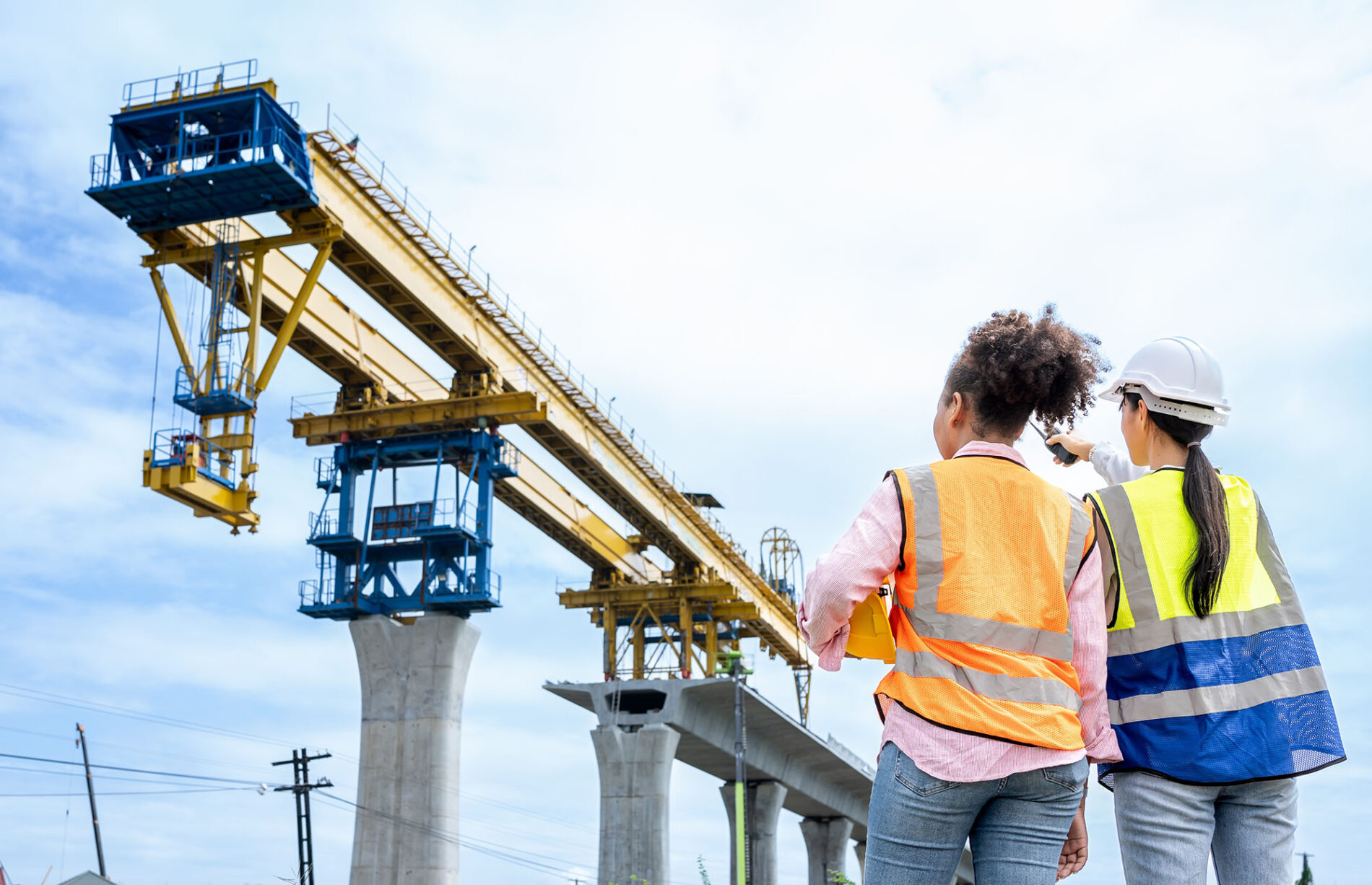 Civil engineer checking work with walkie-talkie for communication to management team in the construction site.Female project manager team communicate team using walkie talkie.Project management.