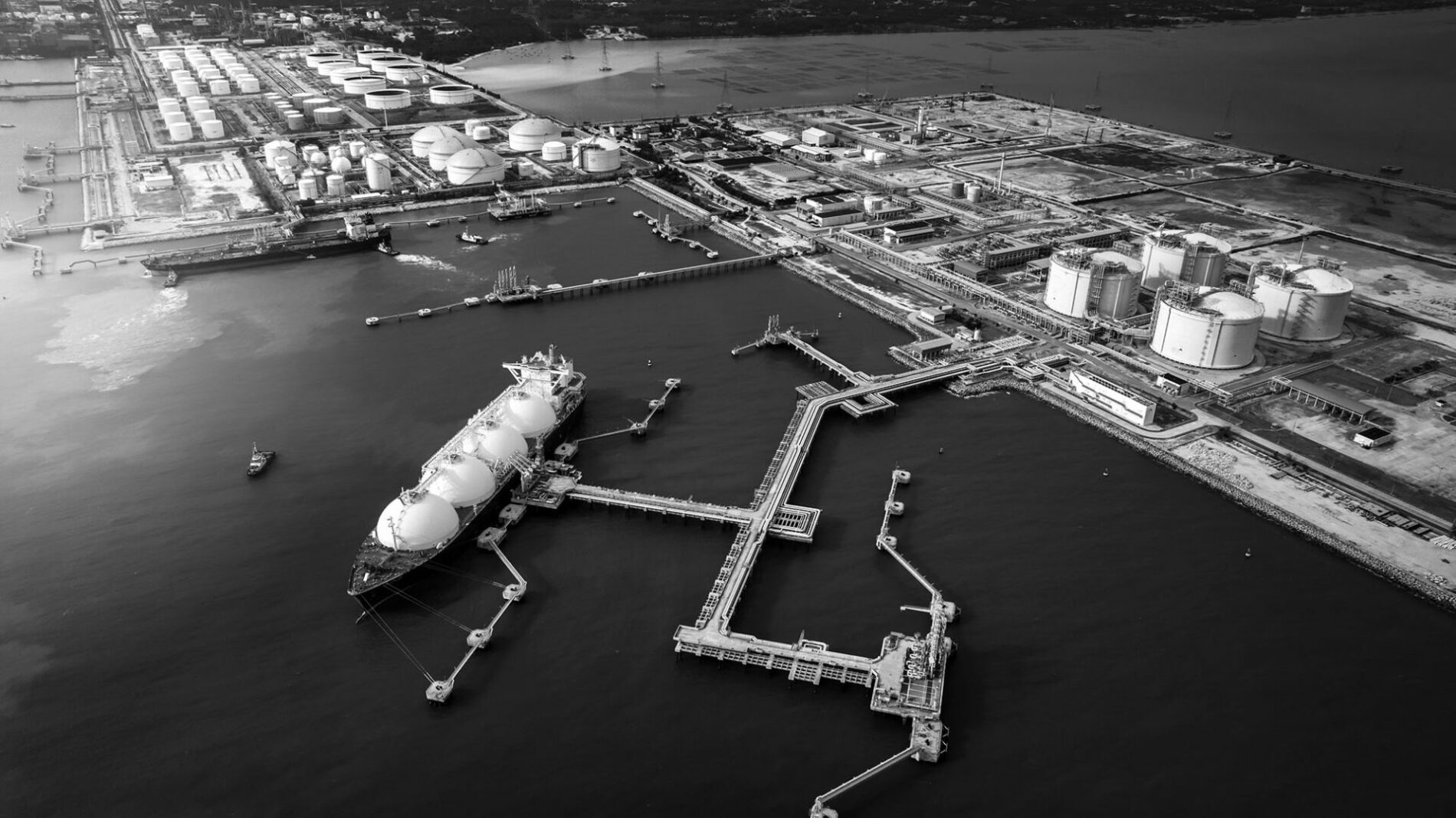 LNG (Liquified Natural Gas) tanker anchored in Gas terminal gas tanks for storage. Oil Crude Gas Tanker Ship. LPG at Tanker Bay Petroleum Chemical or Methane freighter export import transportation